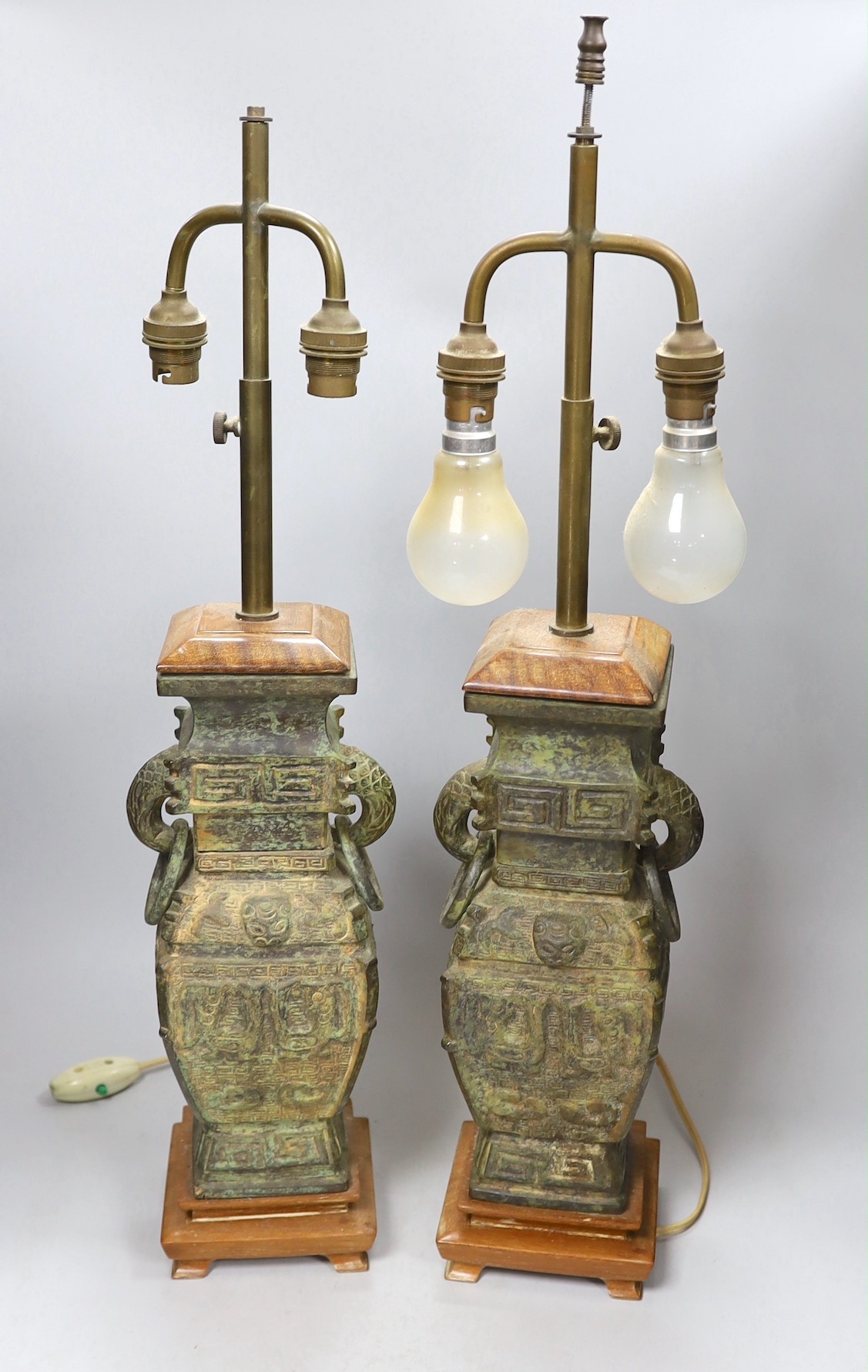 A pair of archaic Chinese bronze vases, converted into table lamps, 62cms high including light fitting